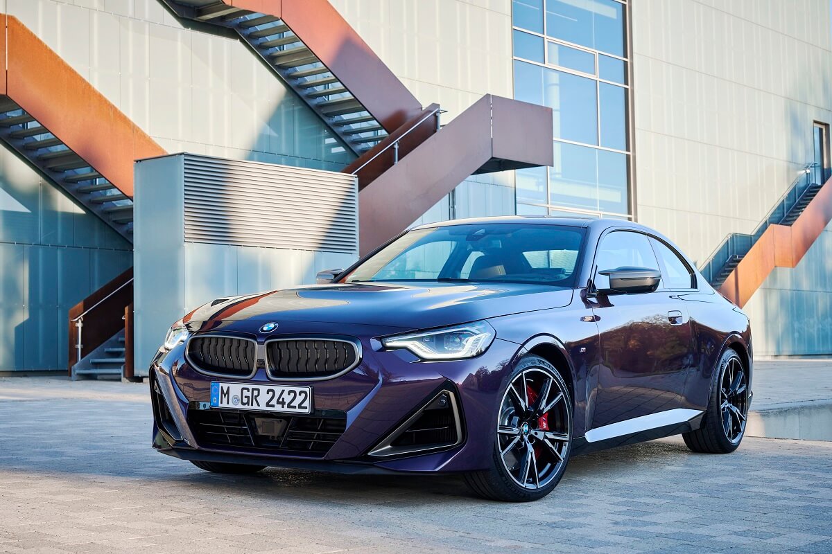 A purple BMW M240i poses in front of a staircase.