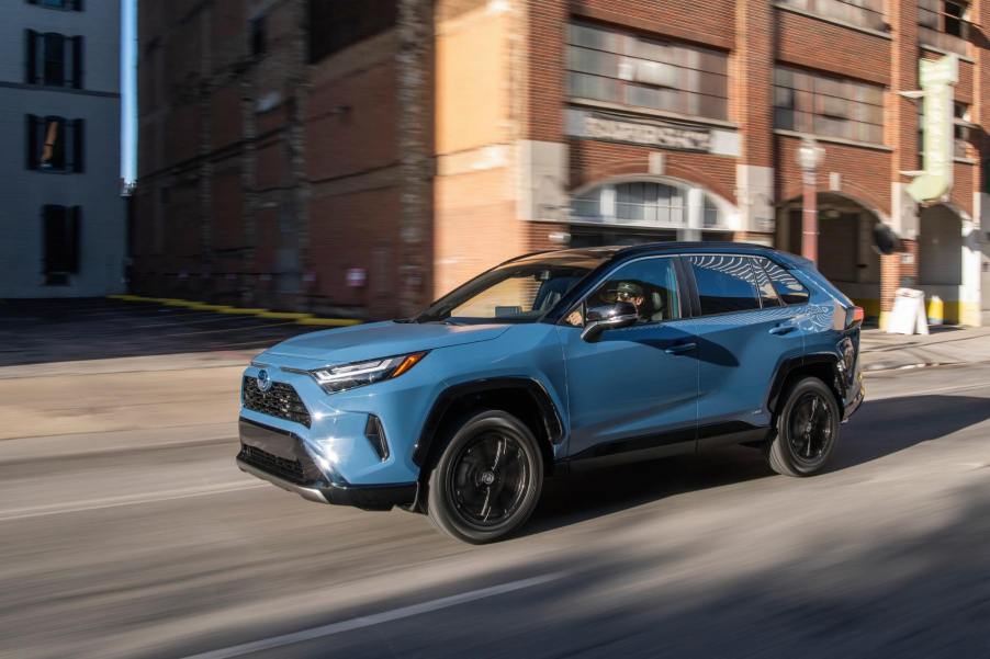 A blue Toyota RAV4 drives on a city street. The RAV4 failed to earn the title of best compact SUV for the money.