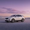 A white Cadillac XT5 sits on the salt flats at dusk.