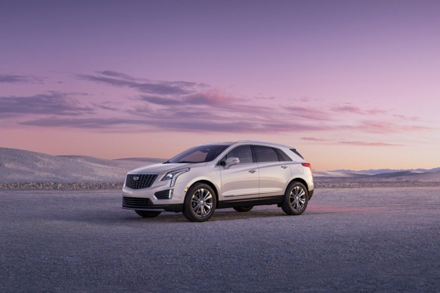 A white Cadillac XT5 sits on the salt flats at dusk.