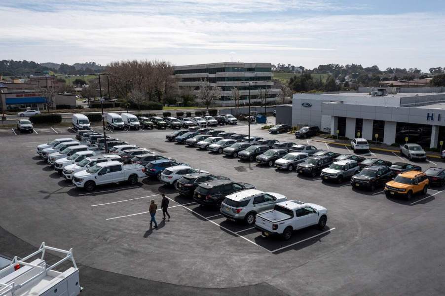 A new car lot, where mechanics could recommend used over new cars, with many options parked across the lot.