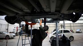 A mechanic technician performing maintenance on an electric vehicle at the Revolte e-garage in Carquefou, France