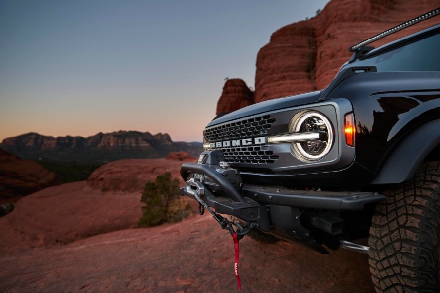 Front end of a black Ford Bronco on a red rock off-road trail.