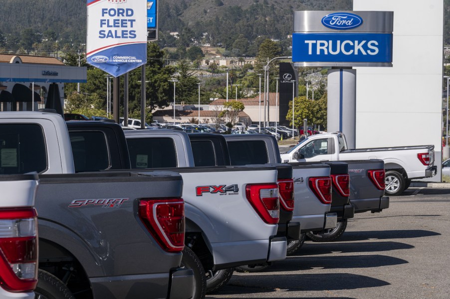 A Ford Motor Dealership with a parking lot full of Ford pickup trucks.