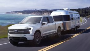 A 2023 Ford F-150 Lightning electric truck tows a trailer.