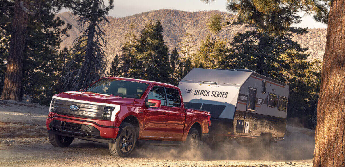 A Ford F-150 Lightning Pro tows a trailer.