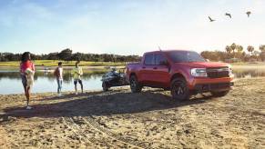 A 2023 Ford Maverick tows a boat out of the water as a small truck.