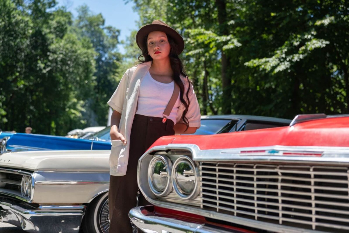 A young woman observing the number one thing you should never do at a car meet.