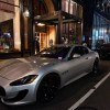 A silver Maserati GrandTourismo parked on a dark street