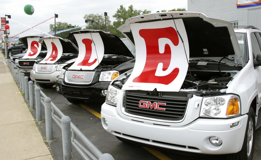 New SUVs on a car lot with a SALE sign