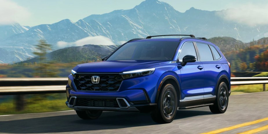 A blue 2023 Honda CR-V small SUV is driving on the road. 