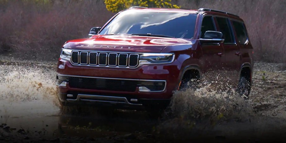 A red 2023 Jeep Wagoneer full-size SUV is driving off-road. 