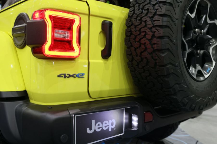 The back of a yellow Jeep Wrangler 4xe at an auto show.