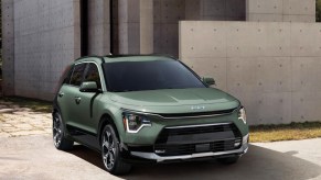 A green Kia Niro subcompact hybrid SUV is parked.