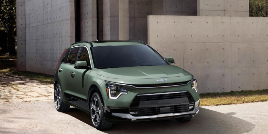 A green Kia Niro subcompact hybrid SUV is parked.