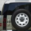 The rear-mounted spare steel wheel on a Land Rover Defender.