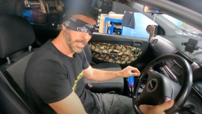 Man in a car with a blindfold, showing how it’s illegal to drive with one in the state of Alabama