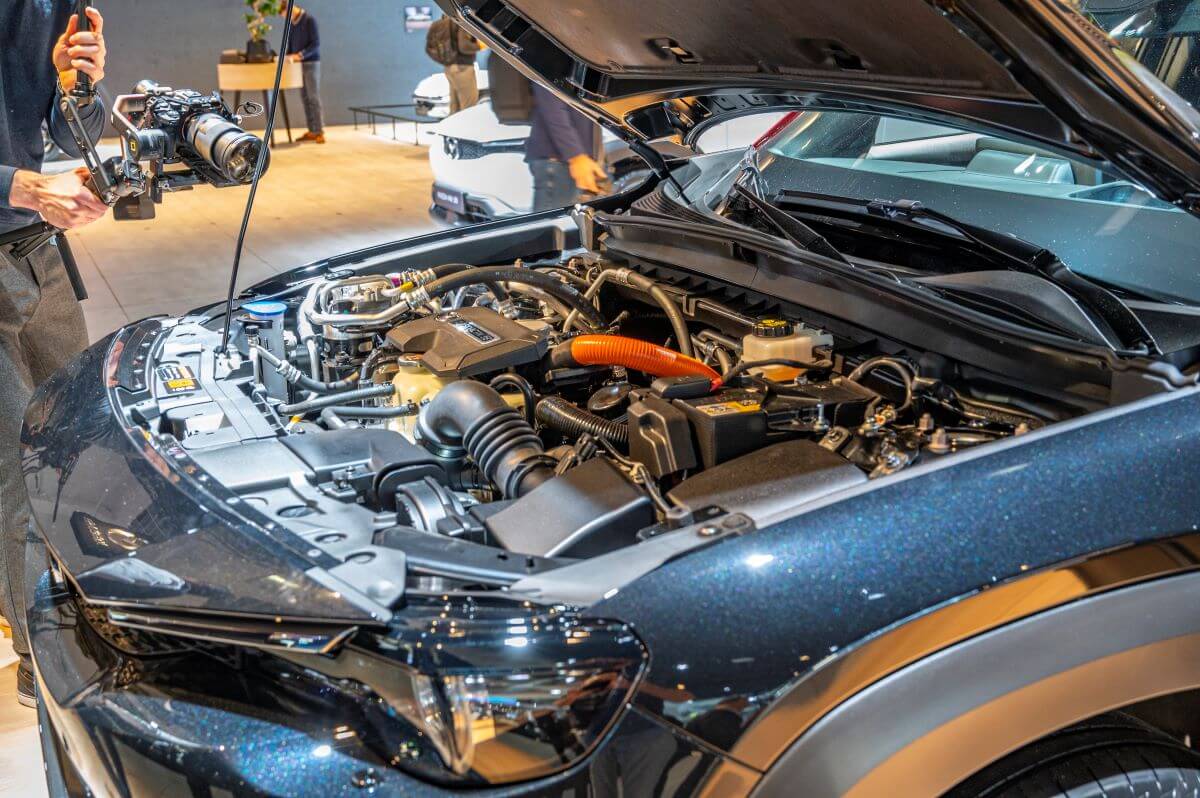 Under the hood of a Mazda MX-30 R-EV model showing its powertrain with a Wankel rotary engine range extender