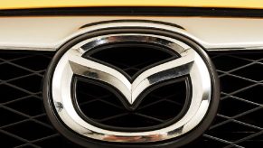 A Mazda3 car badge shines on a yellow front end.