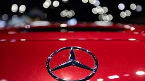 A Mercedes-Benz logo on the front of a red Mercedes-Benz vehicle.