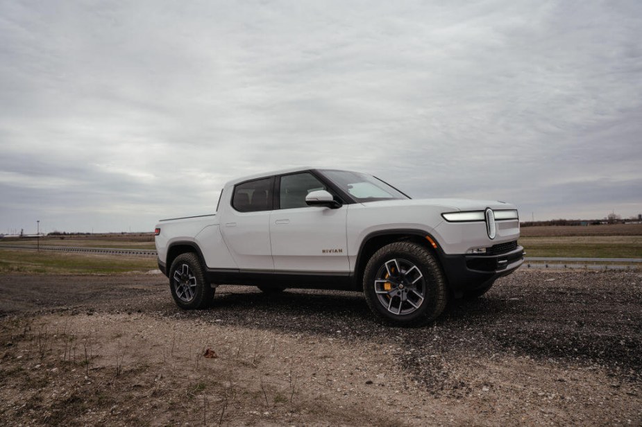 A 2023 Rivian R1T is parked on a dirt road as an electric truck.