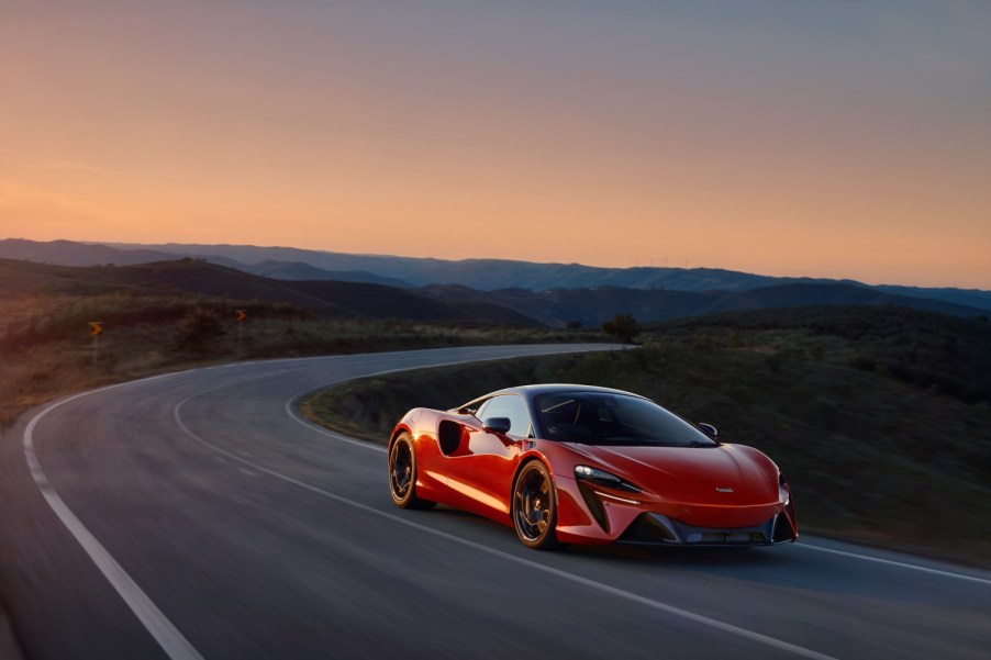 A red McLaren Artura on a winding mountain road