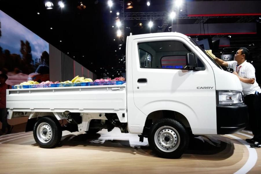 A Suzuki Carry mini-truck is on display at an auto show.