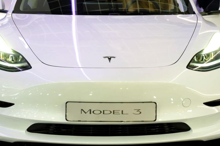 A white Tesla Model 3 luxury compact electric sedan model at the 100th edition of the Brussels Motor Show