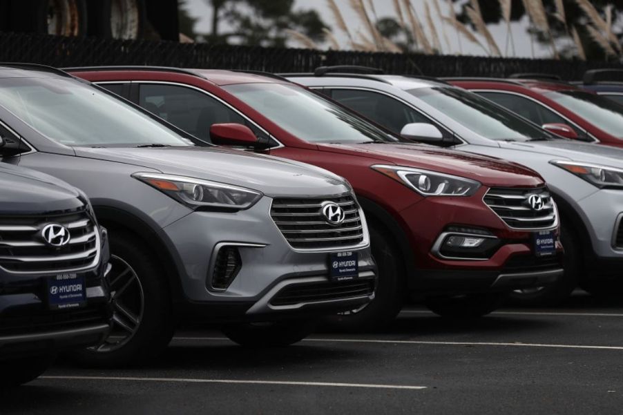 2011 Hyundai Santa Fe SUVs sitting on a dealership lot.