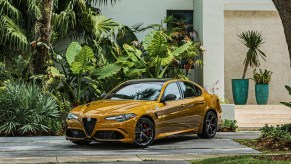 A mustard colored Alfa Romeo Giulia Quadrifoglio parked at a house