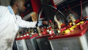 Old car batteries being recharged and recycled for components at a second-hand battery shop in Nairobi, Kenya