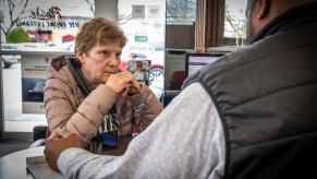 A customer sits in front of a salesperson at a dealership.