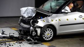 A frontal crash test with another vehicle with crash test dummies not wearing seat belts in Paris, France