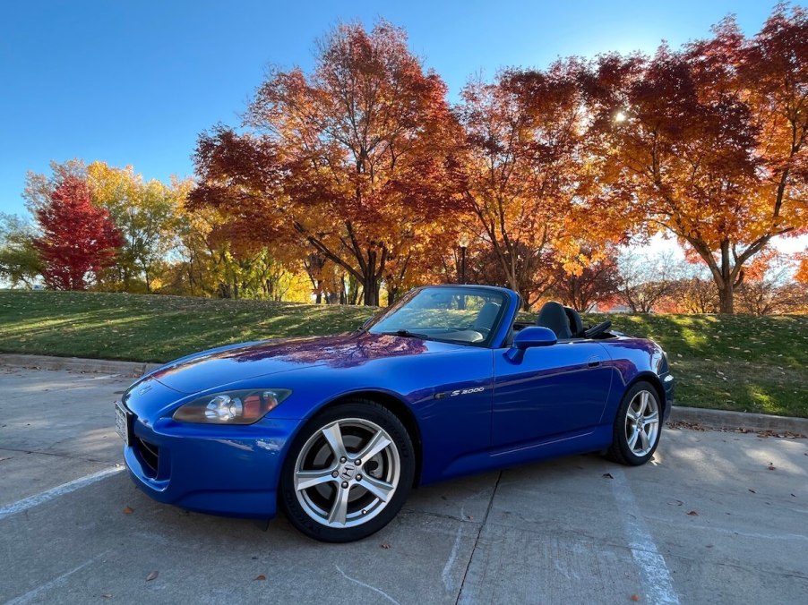 My 2008 Honda S2000 posing in the sunlight next to trees.