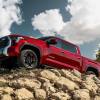 A red 2023 Toyota Tundra Unlimited full-size pickup truck model parked on a hill of dirt and stones