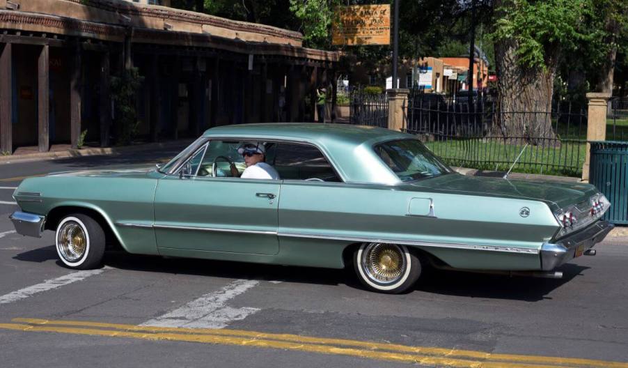 A man driving a 1963 Chevy Impala SS customized into a lowrider model in Santa Fe, New Mexico