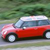 A red 2002 Mini Cooper driving down a side road