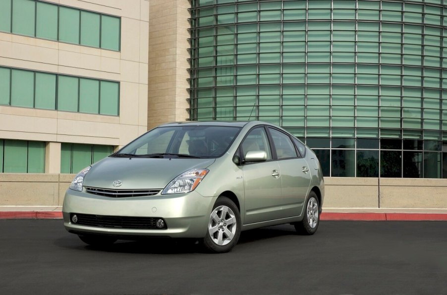 A used 2008 Toyota Prius parks next to a business complex.