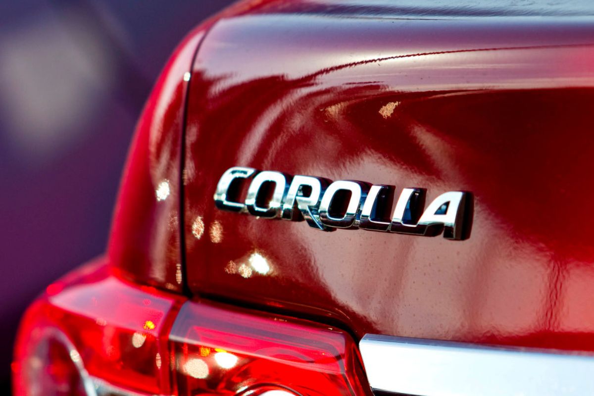 A close up view of a Toyota Corolla nameplate on a red 2011 model.