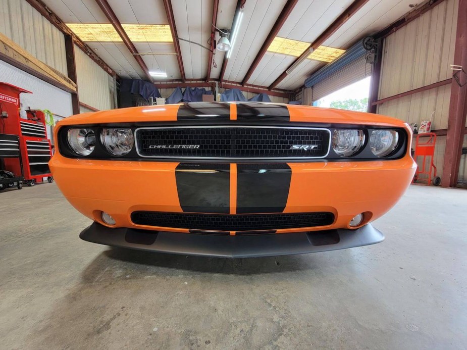 Closeup of hte grille of a Challenger SRT, a garage lined with toolboxes visible in the background.