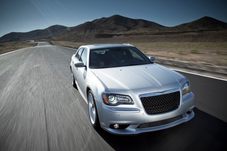 A silver 2014 Chrysler 300 SRT8 drives across an open road.