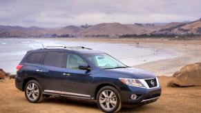 A blue 2014 Nissan Pathfinder on the beach. This SUV has serious transmission problems