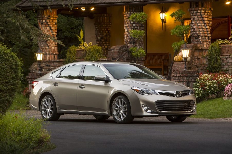 A used 2015 Toyota Avalon parks next to a nice restaurant.