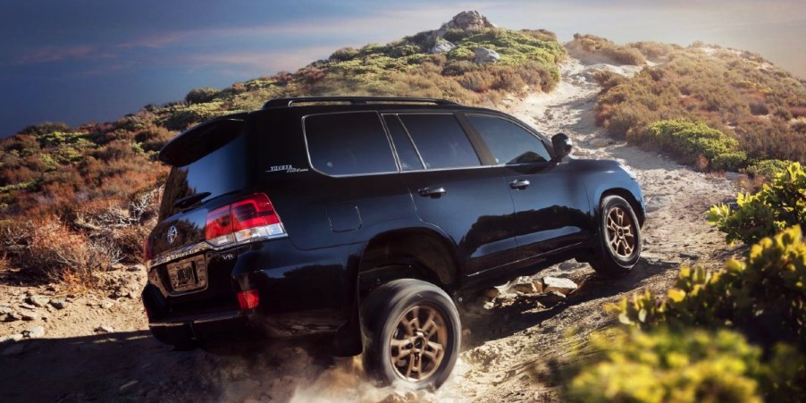 A blue Toyota Land Cruiser full-size SUV is driving off-road.