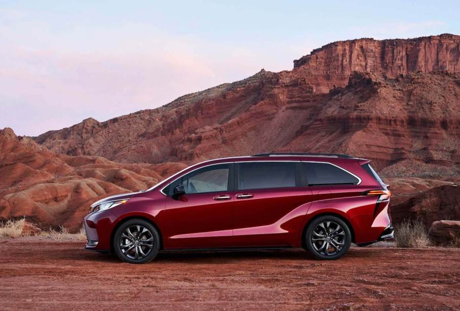 A red Toyota Sienna parked in front of a canyon.