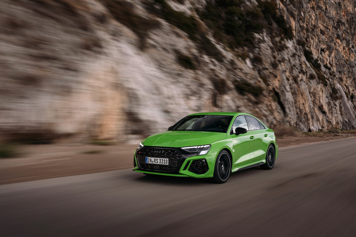 A lime green 2023 Audi A3 Sedan driving down the road