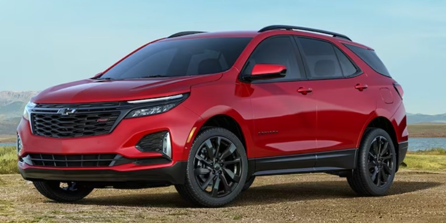 A red 2023 Chevrolet Equinox small SUV is parked off-road.