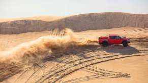 A red 2023 Ford F-150 Raptor in the middle of the desert.