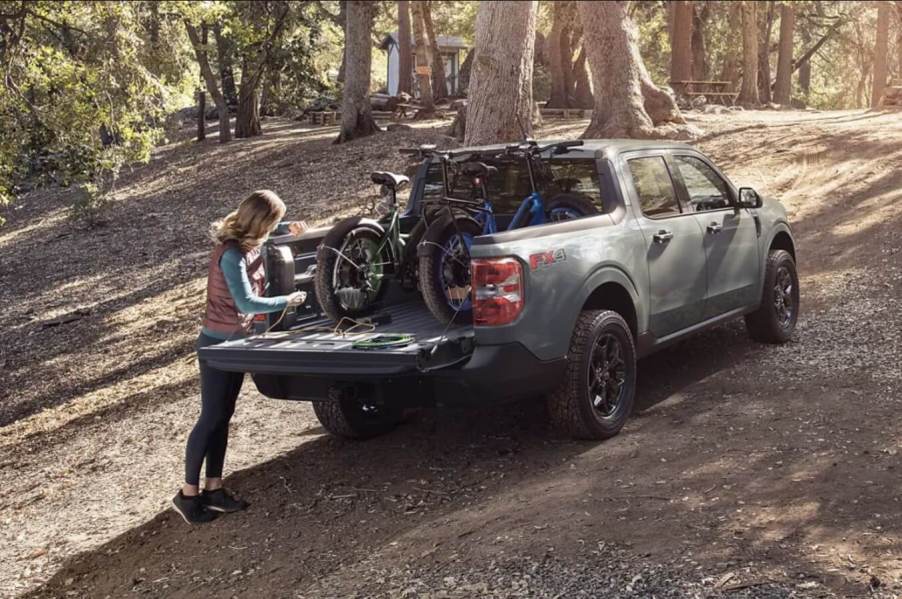 A Ford Maverick owners putting a bike in the bed of the truck.