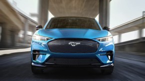 A blue 2023 Ford Mustang Mach-E small electric SUV is driving.